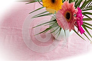 Bouquet of pink daisies in white vase on pink background, colorful flowers view above