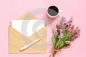 Bouquet of pink flowers, envelope with white blank card for text and cup of coffee on pink background Greeting card Flat Lay Mock