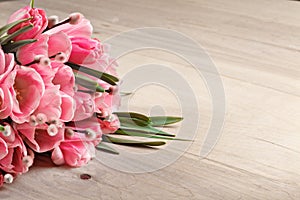 Bouquet of pink fresh tulips on wooden background