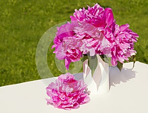 A bouquet of pink peonies in a vase.