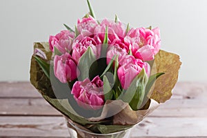 Bouquet of pink peony tulips on a wooden background. Spring flowers. Mother`s Day background.