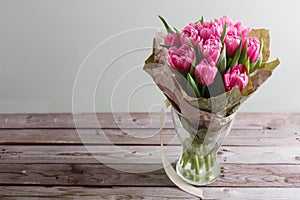 Bouquet of pink peony tulips on a wooden background. Spring flowers. Mother`s Day background.