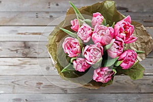 Bouquet of pink peony tulips on a wooden background. Spring flowers. Mother`s Day background.