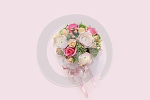 Bouquet with pink ranunculuses and roses in a gift box with ribbons on a pink background