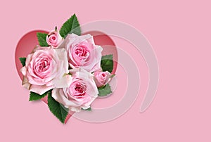 Bouquet of pink rose flowers in a heart shape frame on pink background