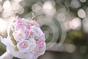 A bouquet of pink rose flowers used by the bride to carry the wedding. On a bokeh background