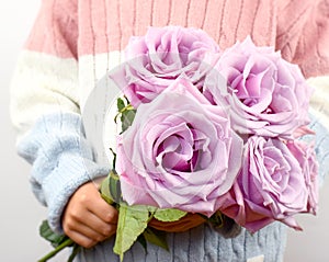 Bouquet of pink roses on the background of clothes.