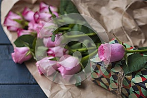 A bouquet of pink roses, a box with a gift. Sweet pasta macaroons of different colors, on Valentine`s Day