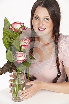 Bouquet of pink roses and brunette young woman with pigtails