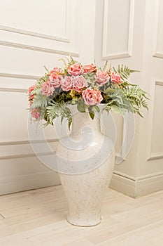 Bouquet of pink roses in floor ceramic vase in classic style. Shbby chic interior decoration