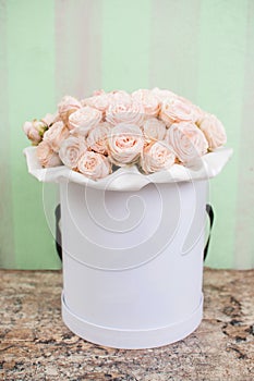 A bouquet of pink roses flowers in a whit round box