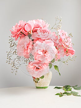 Bouquet of pink roses in a vase on a gray background