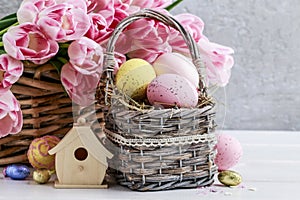 Bouquet of pink tulips and basket of Easter eggs