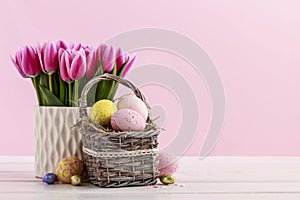 Bouquet of pink tulips and basket of Easter eggs