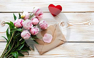 Bouquet of pink tulips, envelope and red heart on white wooden background, Valentines Day, International Women's Day, Mothers day