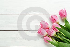 A bouquet of pink tulips on a white wooden background