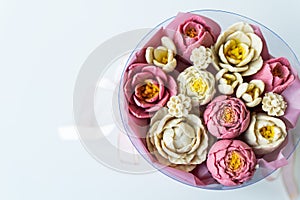 A bouquet of pink and white flowers made from soap. Flowers are collected in a round pink box with a pink ribbon. Place