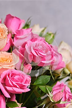 Bouquet of pink and white roses on a grey background.