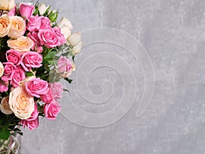 Bouquet of pink and white roses on a grey background.