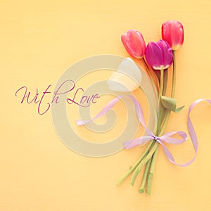 bouquet of pink and white tulips over pastel wooden background. Top view. International women day concept.