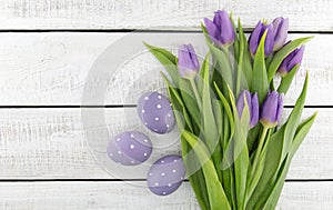 Bouquet of purpleviolet tulips and painted easter eggs on whit