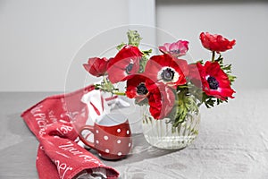 A bouquet of red anemones in a glass vase