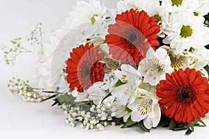 A bouquet of red gerberas, white lilies and daisies, isolated on a white background.
