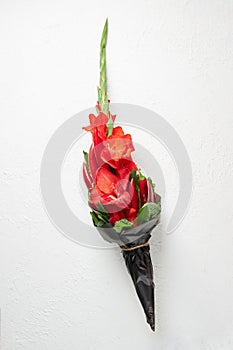 Bouquet of red gladioluses, red pepper, decorated with bay leaves and broccoli on a white background