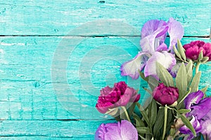 Bouquet of red peony and Iris on turquoise rustic wooden backgro