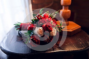 Bouquet of red and pink roses on table near window