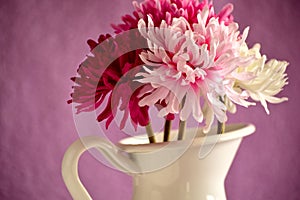 Bouquet of red, pink and white flowers in a white metal vase