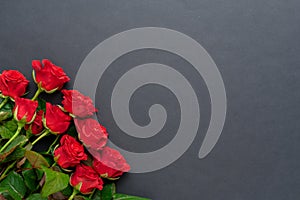 A bouquet of red roses with a beautiful ribbon on a black background, copyspase