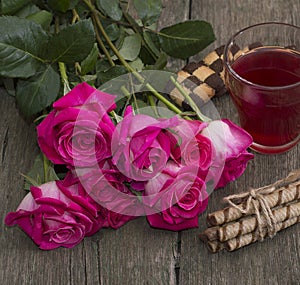 Bouquet of red roses, drink and cookies in a sheaf, a still life