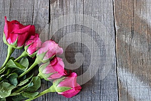 Bouquet of red roses on old wooden board background with copy space for massage. Valentine`s day concept or wedding card