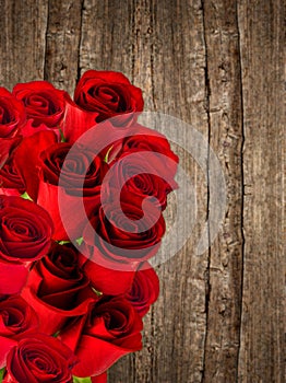 Bouquet of red roses over wooden background