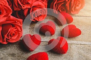 Red roses, red heart shape on a wooden table