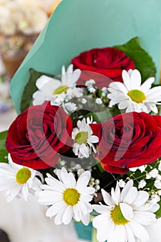 a bouquet of red roses and white daisies