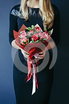 Bouquet of red tulips in girs hands. Unrecognisable.