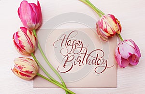 Bouquet of red tulips on white background with text Happy Birthday. Calligraphy lettering