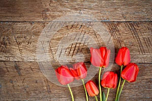 Bouquet of red tulips on wooden retro grunge background with copy space