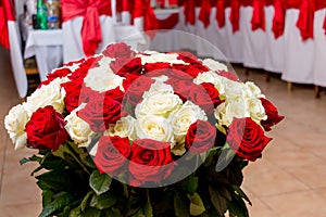 Bouquet of red and white roses near the festive table in the res
