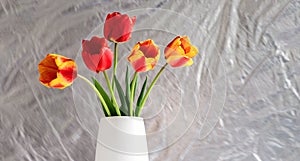 Bouquet of red and yellow tulips in a white vase