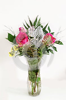 Bouquet with roses in a glass vase on a white background