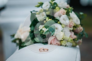 Bouquet of roses with golden wedding rings