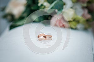 Bouquet of roses with golden wedding rings