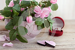 Bouquet of roses and hearts on a wooden background.