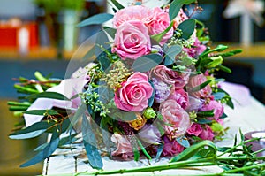 Bouquet of Roses is on the table next to the multi-colored ribbons