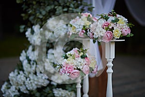 A bouquet of roses on a white stand as a wedding decor