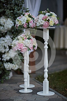 A bouquet of roses on a white stand as a wedding decor