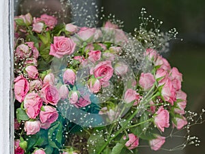 Bouquet of small pink roses behind the glass